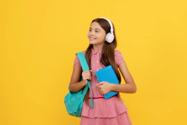 happy school child in headphones carry backpack and workbook, ebook