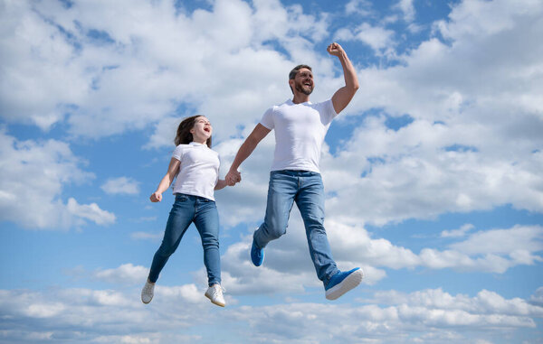 free father and daughter jump in sky.