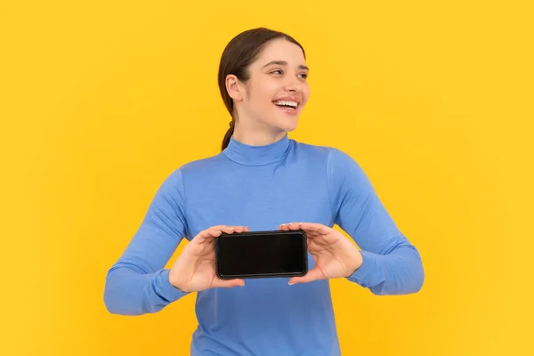 Laughing lady showing smartphone screen with copy space, webinar — Stockfoto