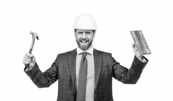 Gelukkig bouwvakker dragen veiligheidshelm met formele pak holding hamer en troffel, gebouw — Stockfoto