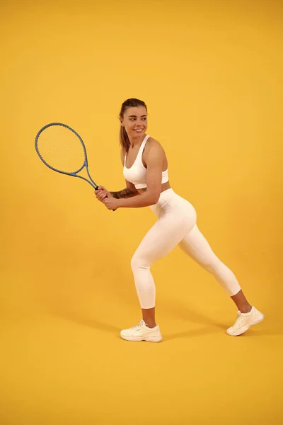 Tennista sorridente correre con racchetta su sfondo giallo, sport — Foto Stock