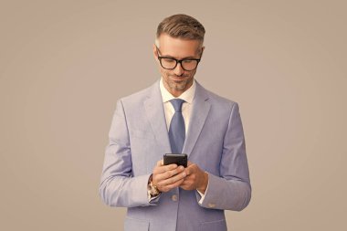 Gözlüklü gülümseyen yakışıklı işadamı. Telefondaki e-postayı kontrol et, blog yazarı.