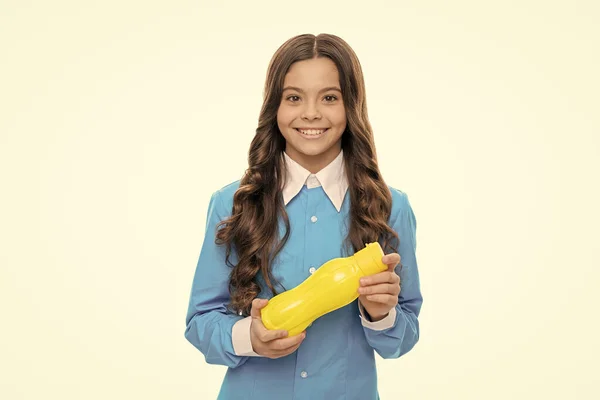 Menina com fome feliz segurar garrafa amarela de plástico com beber iogurte para refeição saudável do café da manhã, fome — Fotografia de Stock
