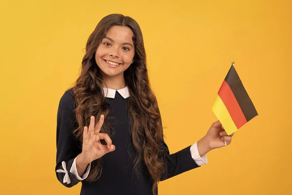 Oké, gesztus. Boldog gyerek, német zászlóval. turisztikai vízum Schengen országban. — Stock Fotó