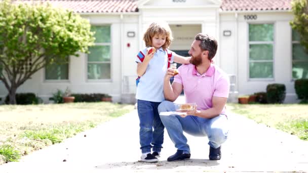 Keluarga bahagia anak laki-laki dan ayah makan siang setelah sekolah, gerak lambat, masa kanak-kanak — Stok Video