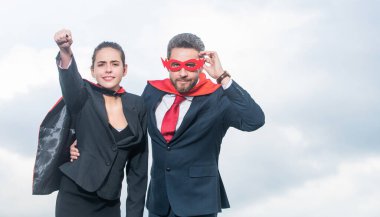 Gökyüzü geçmişinde süper kahraman kıyafetli bir iş çifti. liderlik
