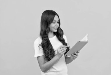 Okumaya hazır gülümseyen liseli kız not defterine ve eğitime not alıyor.