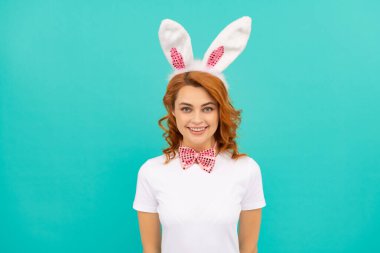 Tavşan kulaklı mutlu Paskalya kadını ve mavi arka planda papyon.