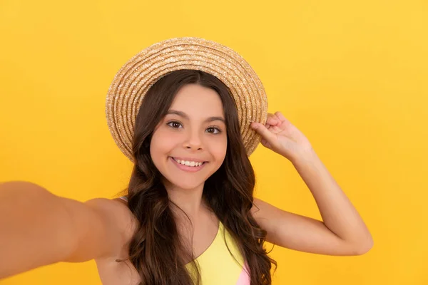 Heureux enfant en été chapeau de paille faire selfie sur fond jaune, avoir du plaisir — Photo