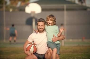 Mutlu baba ve oğul dışarıda basketbol oynuyor, aile içinde.