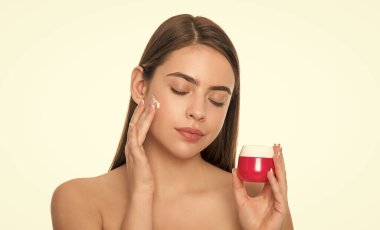 Temizleme fırçası. Bayan kozmetik ürünü sunuyorum. Kadın yüz kremi sürüyor..