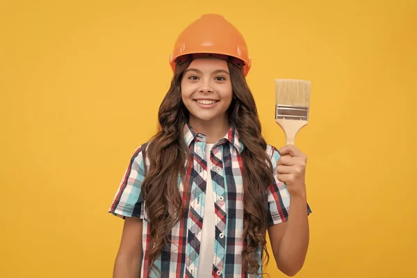 Criança feliz com cabelo encaracolado no capacete de construção segurar pincel pintura, pintor — Fotografia de Stock