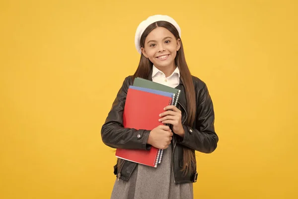 Счастливая девочка-подросток вернулась в школу с книгами на желтом фоне, образование — стоковое фото