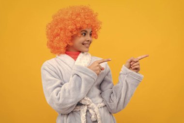 Bornozlu süslü çocuk. Turuncu saçlı mutlu genç kız rahat bir uyku elbisesi içinde..