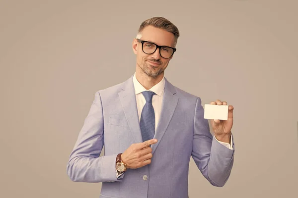 Smiling mature man in glasses pointing finger on credit card and thumb up, copy space, call me — Zdjęcie stockowe