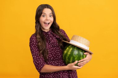 Şok olmuş çocuk elinde kavun tutuyor. Yaz hasır şapkalı karpuz. Meyveli çocuk.