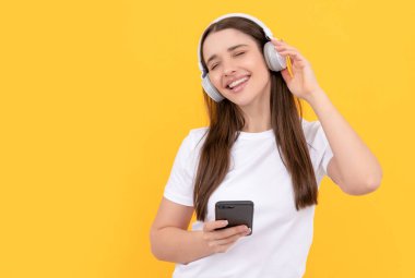 Müzik dinliyordum. Etkileyici bloglar. Sarı arka planda kulaklıklı mutlu kız..