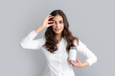 Healthcare and medicine. Portrait of attractive girl holding on bottle pills healthy product over gray background.