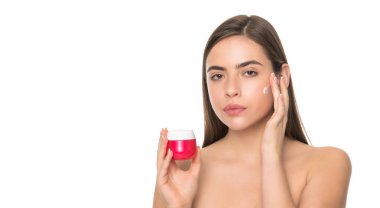 Beyaz arka planda cilt için krem süren genç bir kız fotokopi alanı ve kişisel bakım ile izole edilmiş.