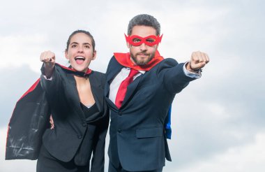 Gökyüzü geçmişinde süper kahraman kıyafetli bir iş çifti. işbirliği