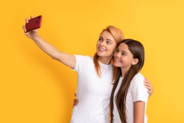 Akıllı telefondan selfie çeken anne, kadın ve kız çocuklarının neşeli aileleri.