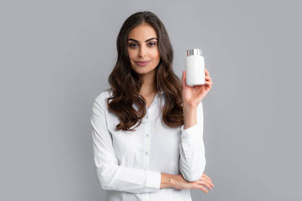 Woman with bottle pills. Pretty woman holding a bottle with dietary supplement, vitamins and minerals. Health, skin and body care concept.