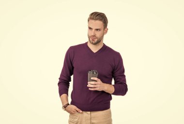 Sabahleyin içilecek ilk şey. Yakışıklı adam, tek kullanımlık bardağı beyazda izole etmiş. Yüksek kafeinli içecek.