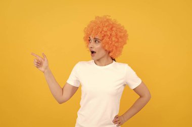 Şuraya bak. Şaşaalı parti bakışı. Palyaço peruklu ucube kadın parmakla işaret ediyor, boşluğu kopyala