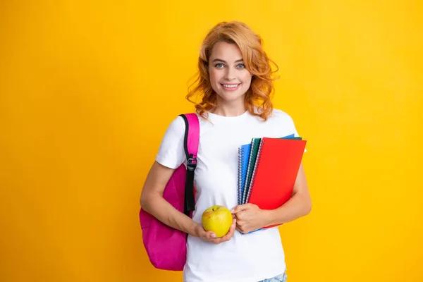 Carino studente donna con zaino detiene alcuni documenti e libri su sfondo giallo. — Foto Stock