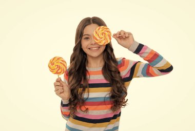 Beyaz arka planda izole edilmiş lolipop şekerli renkli kazaklı mutlu çocuk, çocukluk.