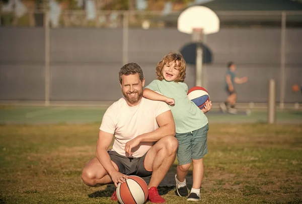 Papá y el niño sostienen la pelota deportiva. niño jugar baloncesto. infancia y paternidad — Foto de Stock