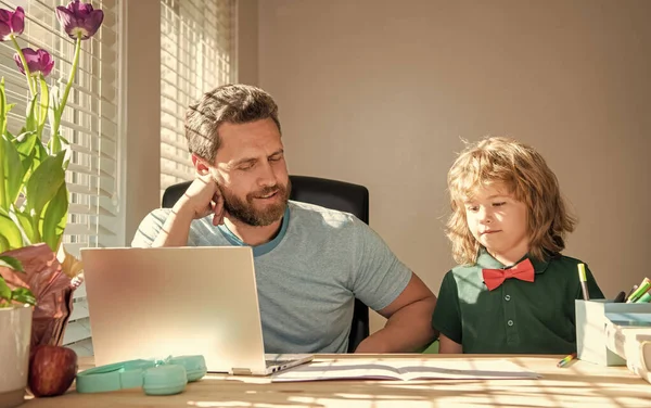 Hombre maduro maestro o papá ayudar a niño hijo con la tarea de la escuela en la computadora, de vuelta a la escuela — Foto de Stock