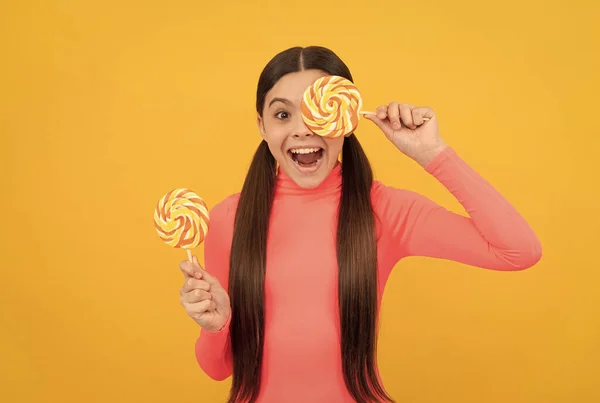 Een lolly kind. kind met lang haar houden lollypop. Snoep op stokje. karamel snoepwinkel. — Stockfoto