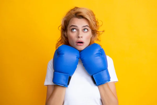 Witzig überraschte Frau in Boxhandschuhen auf gelbem Hintergrund. — Stockfoto