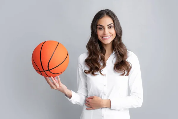 Šťastná usměvavá žena drží basketbalový míč, izolované na šedém pozadí. — Stock fotografie