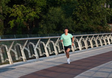 Spor kıyafetleri içinde koşan atletik bir adam.
