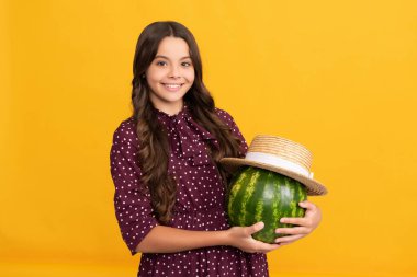 Yaz zamanı. Gülümseyen çocuk karpuzu tut. Yaz hasır şapkalı karpuz. Meyveli çocuk.