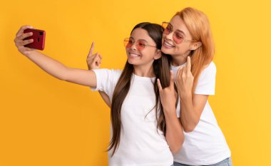 Havalı, mutlu anne-kız, akıllı telefon ve arkadaşlıkla selfie çekiyorlar.