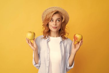 Hasır şapkalı kadın sağlıklı yemek yiyor. Gençlik sağlığı. Doğal organik taze elma.