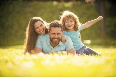 friendship. father mother and child on green park grass. friendly family have fun in summer