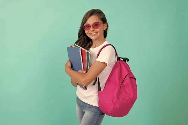 Szczęśliwy dzieciak z plecakiem i copybookiem w okularach przeciwsłonecznych gotowy do nauki w szkole, szkole — Zdjęcie stockowe