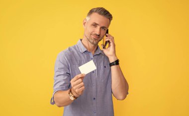 Adam akıllı telefondan konuşuyor. Müşteri paralarını cep telefonunda kullan.