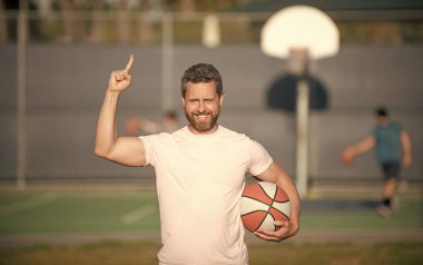 Basketbol topu olan kaslı bir adam. Spor antrenörü ya da basketbol oyuncusu. spor okulu.