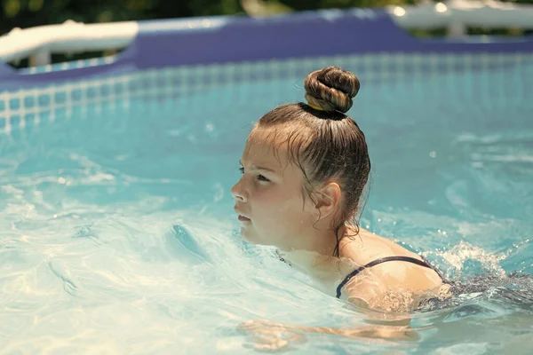 Zachowaj spokój i płyń. Dziewczynka pływa w basenie. Wakacje. Ciepłe słońce i czysta woda — Zdjęcie stockowe