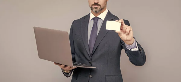 Hombre de negocios recortado en traje de negocios mantenga la computadora y la tarjeta de visita, contáctenos —  Fotos de Stock