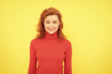 Çekici, mutlu, kızıl saçlı kadın sarı arka planda portre, mutluluk.