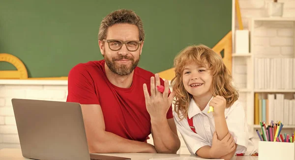 daddy and son study in classroom with laptop, online education