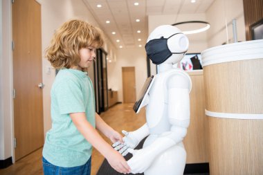 Küçük çocuk robotla yenilikçi bir teknoloji olarak etkileşim içinde. İletişim.