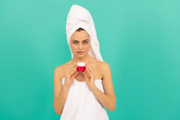 Meisje in handdoek met huid crème op blauwe achtergrond — Stockfoto
