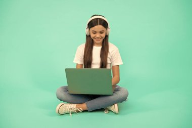 Mutlu kız etkiler video görüşmesi için kablosuz bilgisayar kullanır ya da kulaklıkla webinar dinler, iletişim teknolojisi.